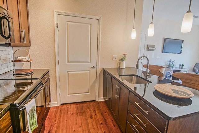 a kitchen with a sink and a stove and a door