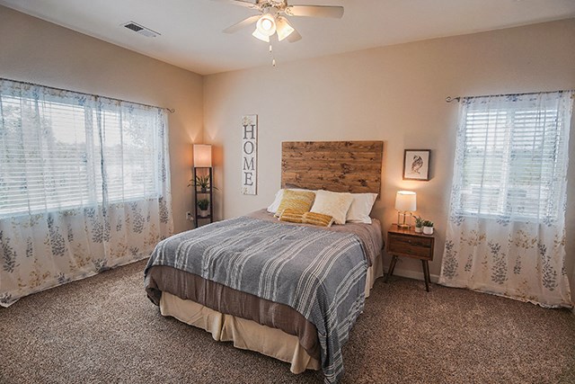 a bedroom with a bed and a ceiling fan