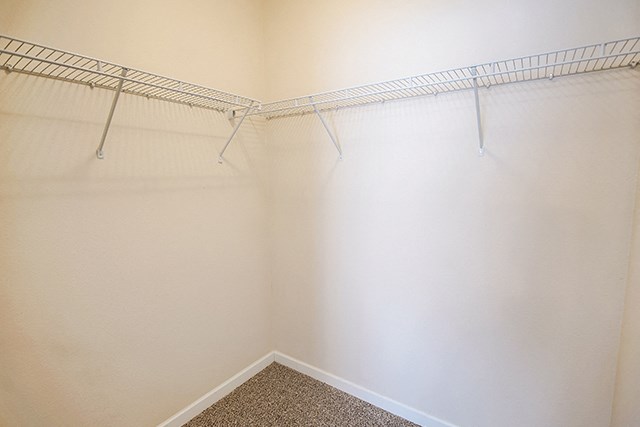 an empty closet with a wire rack on the wall