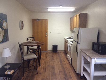a small kitchen with a table and a refrigerator