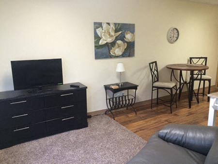 a living room with a television and a table and chairs