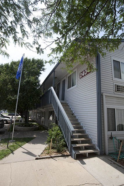 a white house with stairs and a blue flag