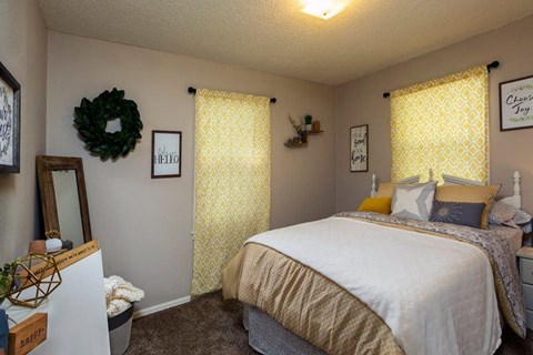 a bedroom with a bed and a window with yellow curtains