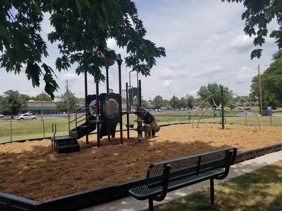 a man playing on a playground at a park