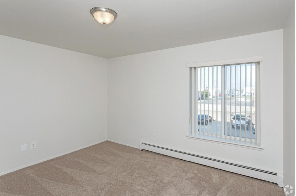 the living room of an empty home with a large window