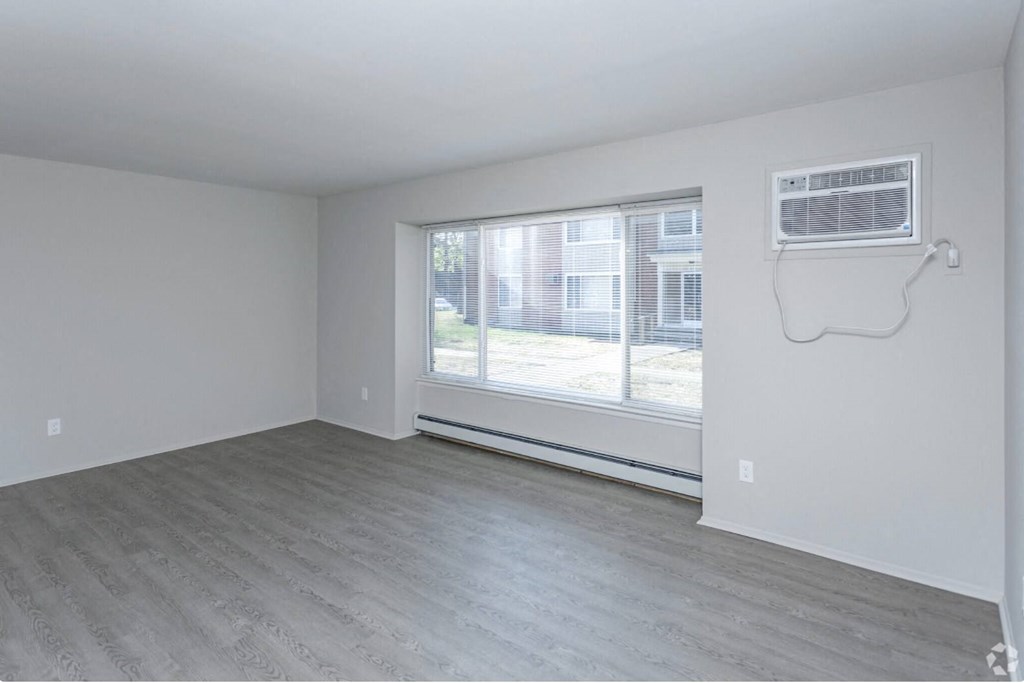 the living room of an empty apartment with a large window
