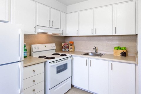 a white kitchen with white appliances and white cabinets