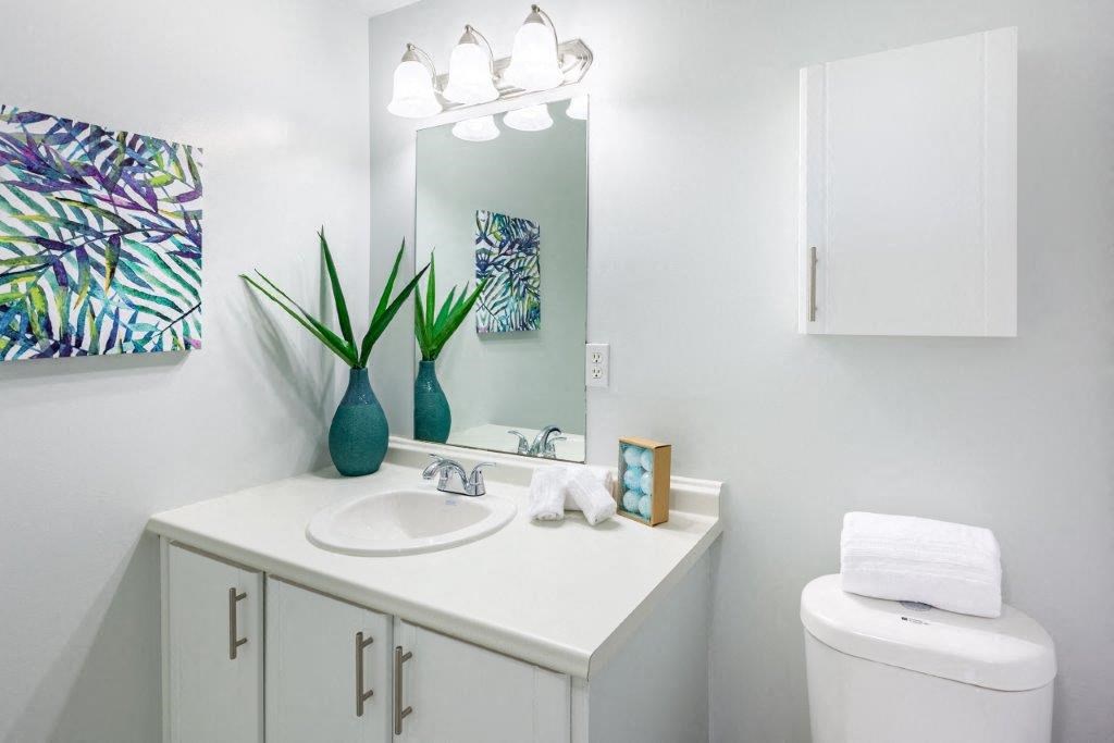 a white bathroom with a sink and a mirror