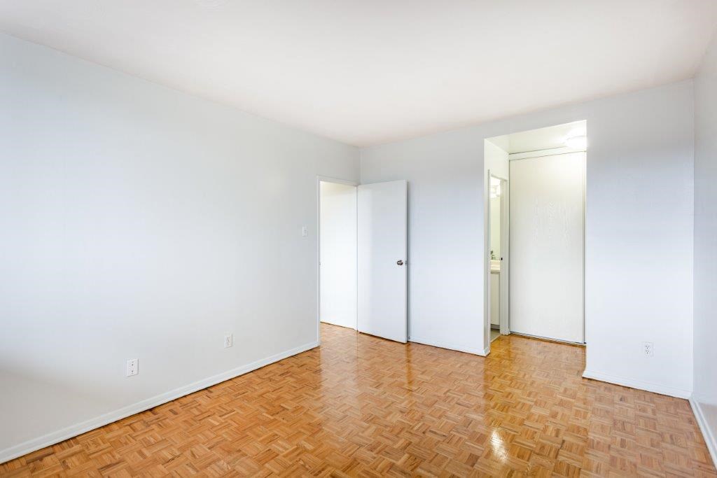 an empty room with a wooden floor and white walls
