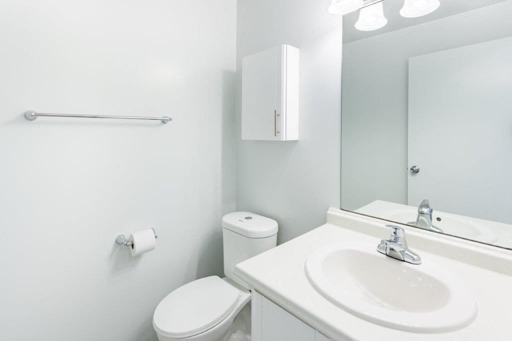 a bathroom with a sink toilet and a mirror