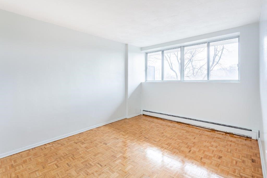 an empty room with a wood floor and a window