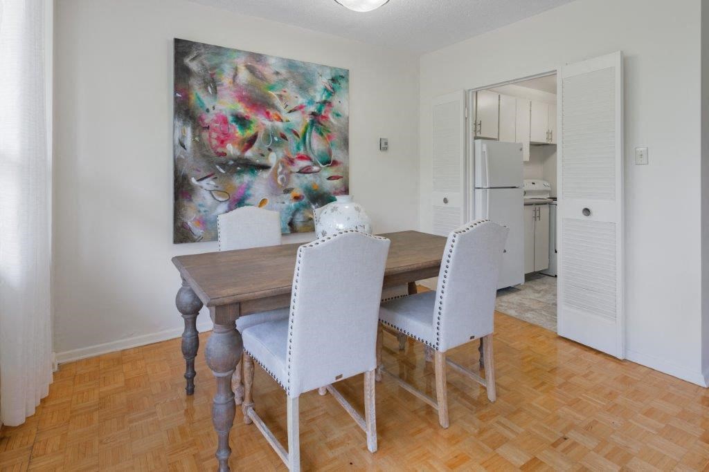 a dining room with a table and chairs and a painting on the wall