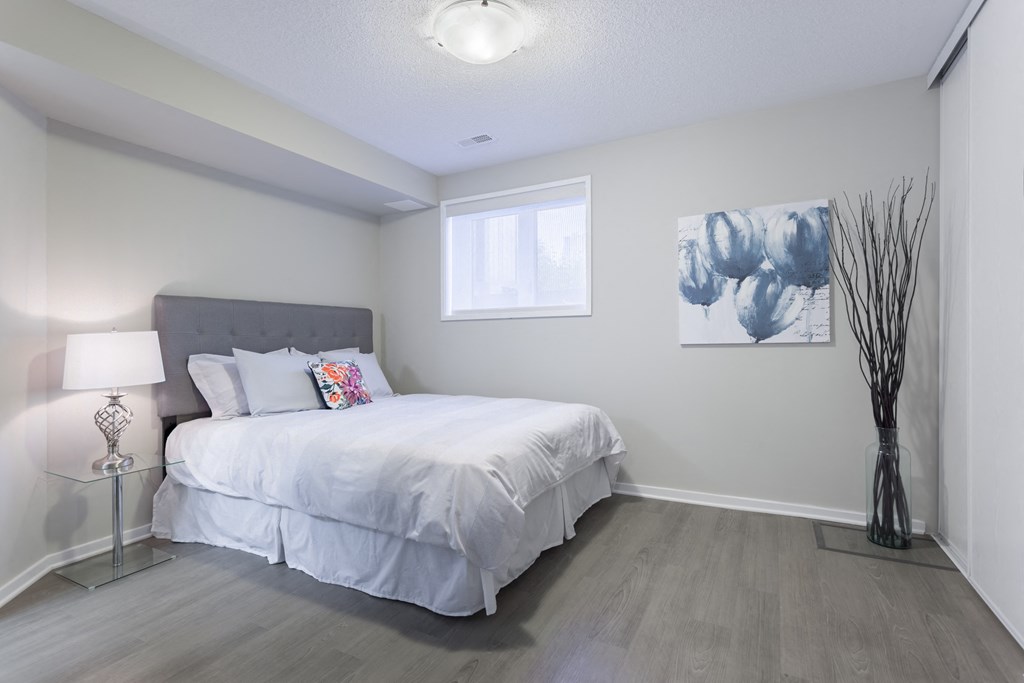 a white bedroom with a bed and a window
