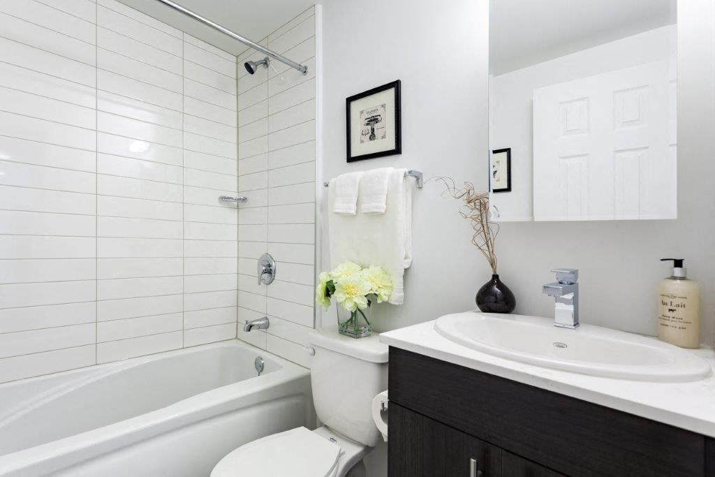 a white bathroom with a sink toilet and tub