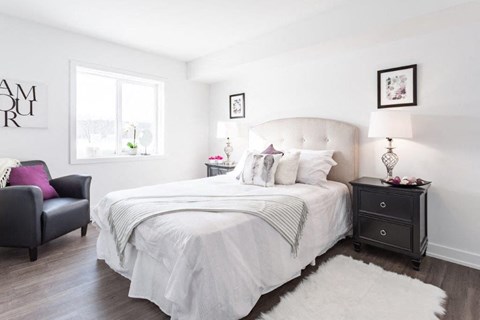 a white bedroom with a bed and a window