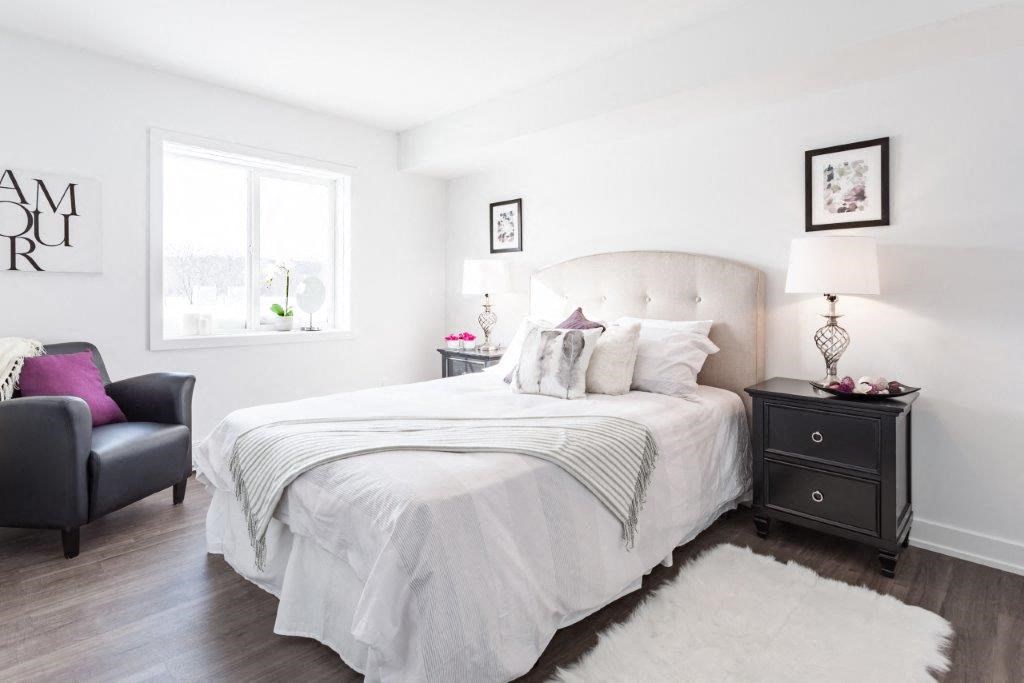 a white bedroom with a bed and a window