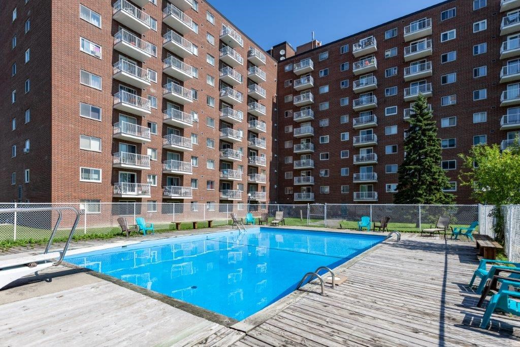 a swimming pool in front of an apartment building