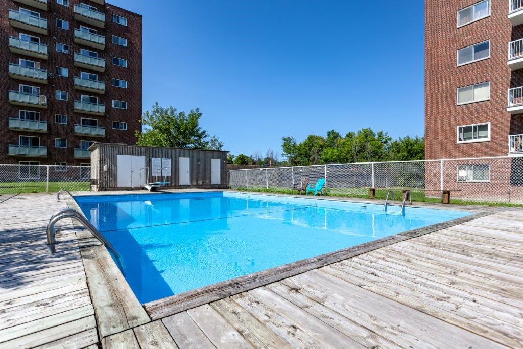 a swimming pool with a fence around it in front of a building