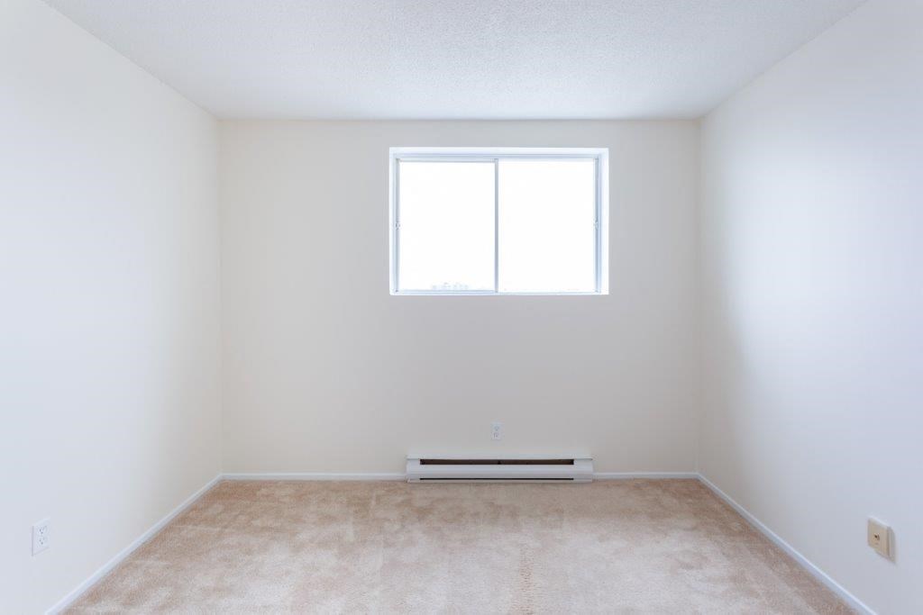 an empty room with a window and a carpet