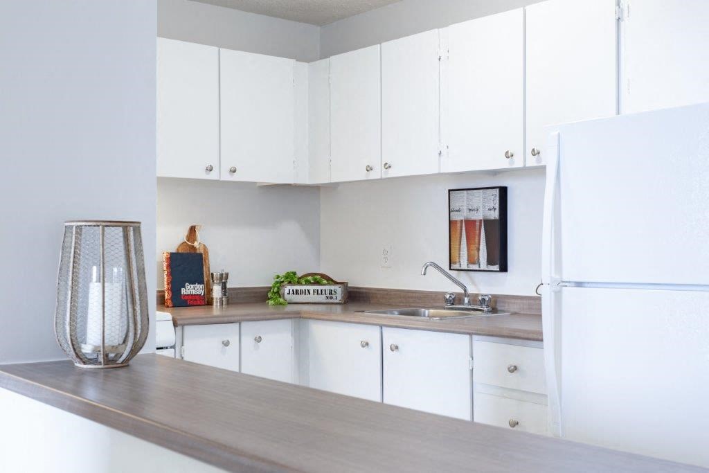 a kitchen with white cabinets and a white refrigerator