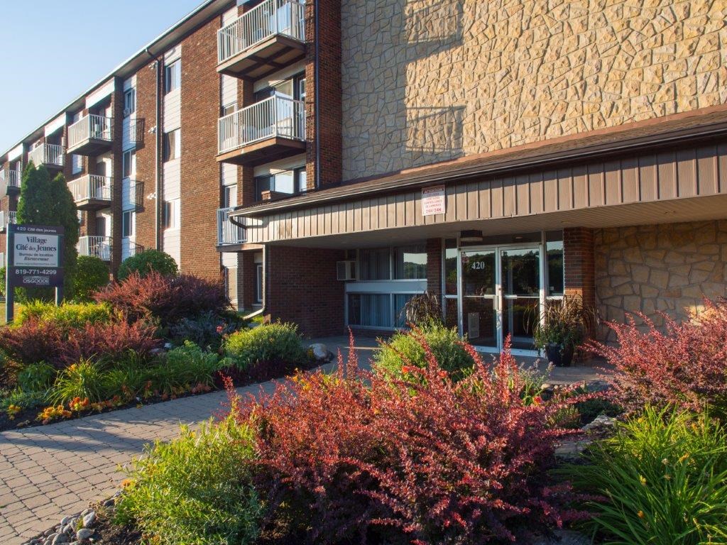 the front of a brick building with a garden in front of it