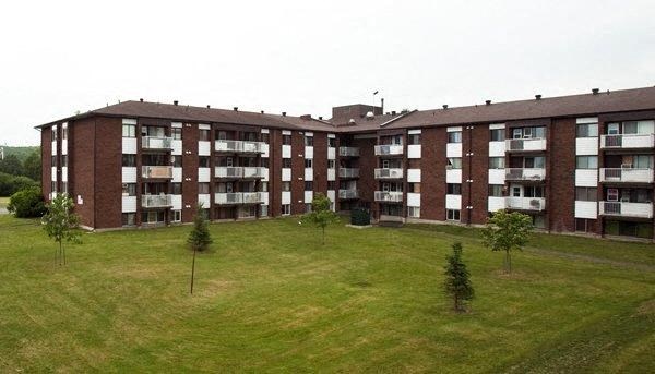 a large brick building with trees in the grass