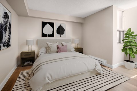 A bedroom with a large bed and a plant.
