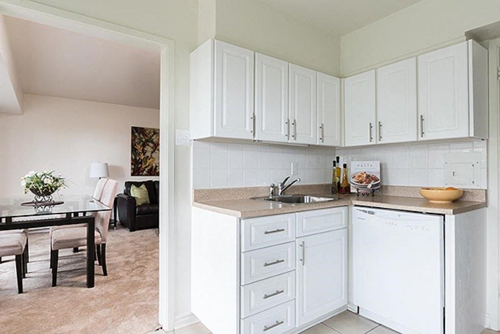 a kitchen with white cabinets and a dining room with a table