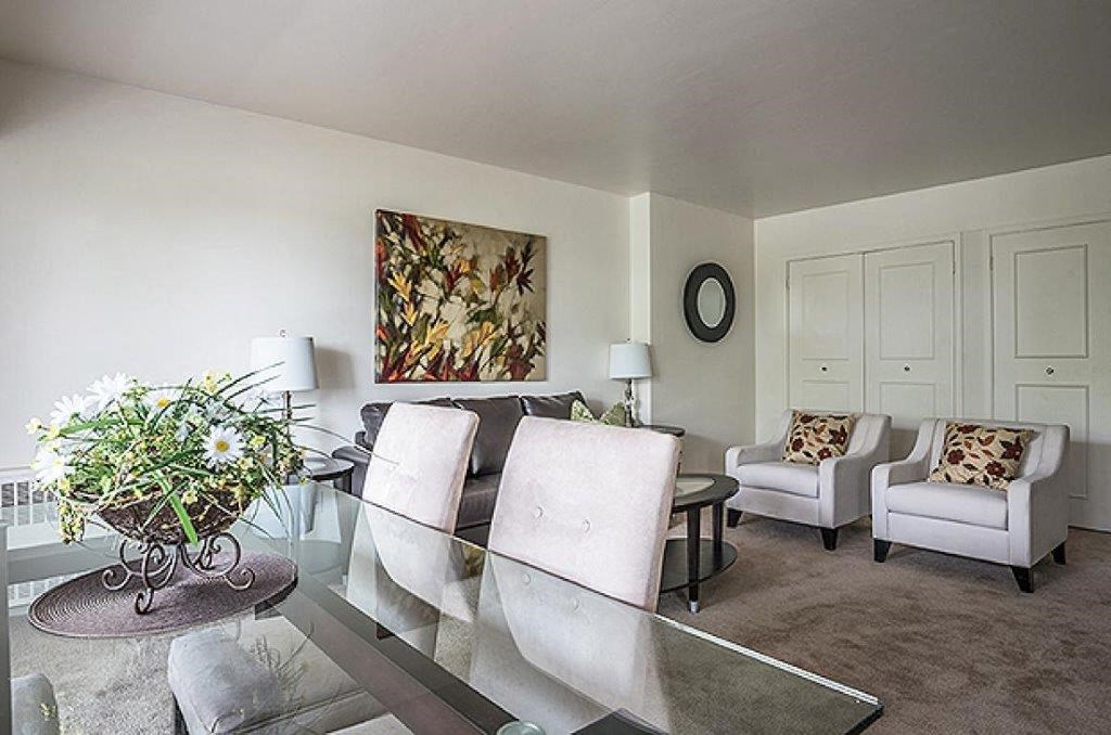 a living room with a glass table and chairs
