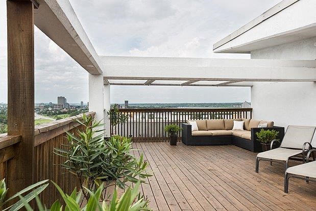a balcony with a couch and chairs on it