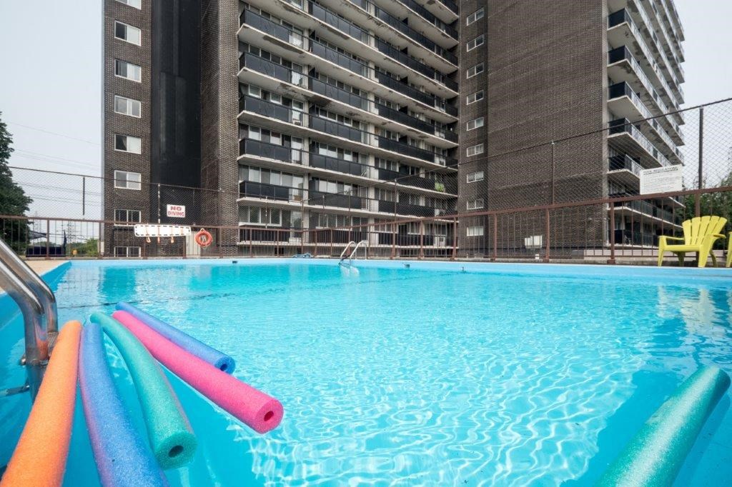an empty swimming pool in front of an apartment building