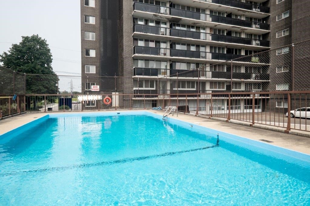 a large swimming pool in front of an apartment building
