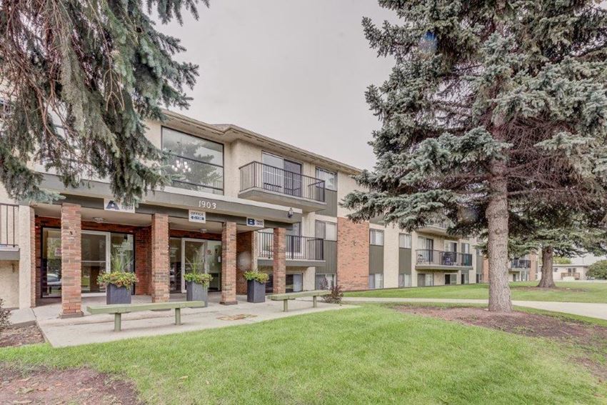 a building with a lawn and trees in front of it
