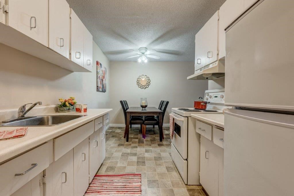 a kitchen with white cabinets and a dining room table