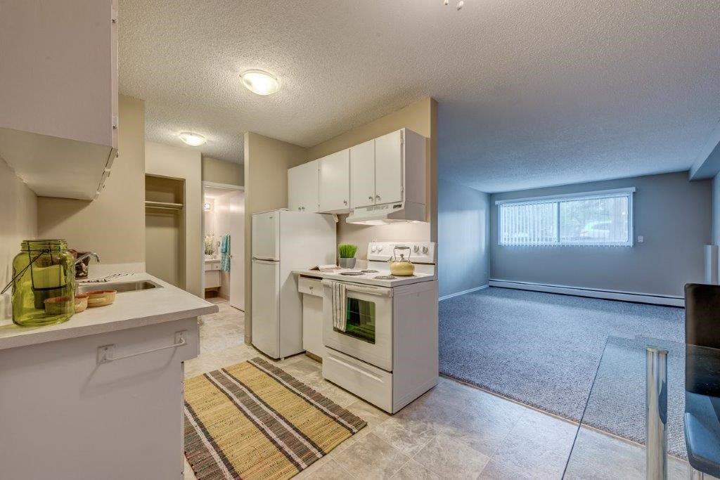 a kitchen with white appliances and a large window