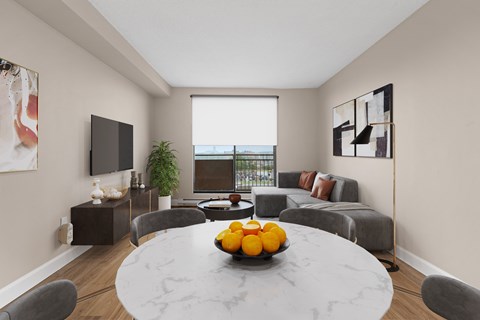 A modern dining room with a round marble table and grey chairs.