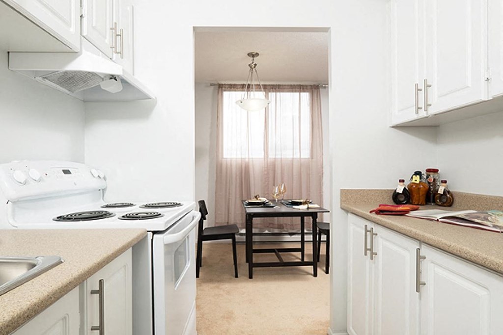 a kitchen with a stove and a table with a window