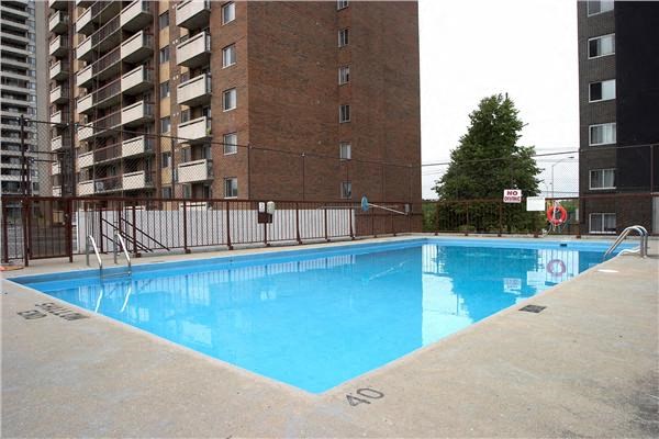 a blue swimming pool in front of an apartment building