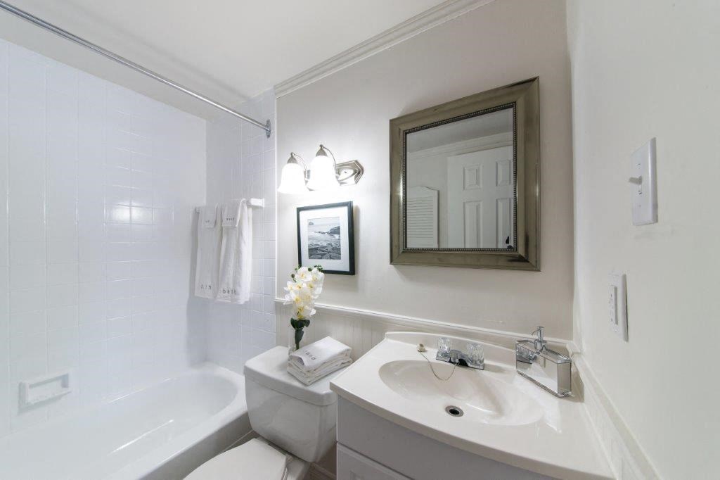 a white bathroom with a sink and a mirror