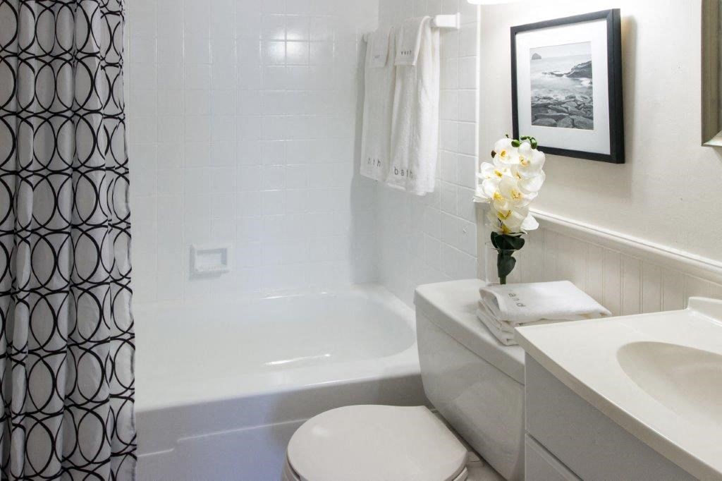 a white bathroom with a white toilet and a tub