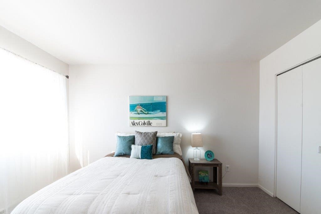 a bedroom with a large white bed and a window