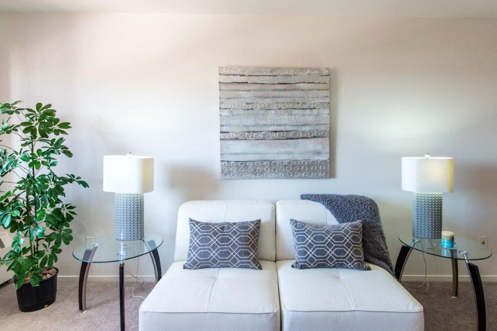 a living room with a couch and a painting on the wall