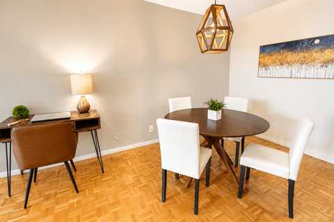 A dining room with a round table and chairs.