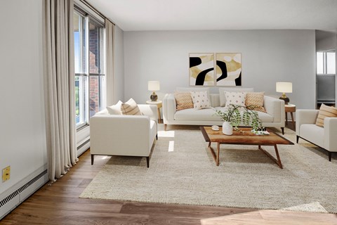 A living room with a white couch, a coffee table, and a painting on the wall.