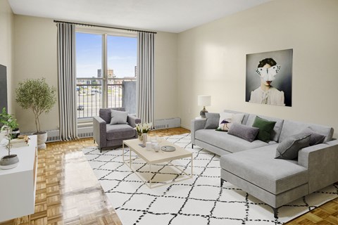 A living room with a grey couch, a coffee table, a chair, a potted plant, and a painting on the wall.