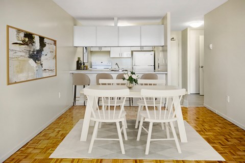 A dining room with a white table and chairs.