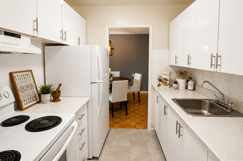 A kitchen with white appliances and cabinets.