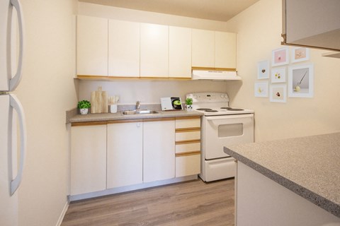 A kitchen with white cabinets and a white fridge.