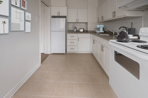 A kitchen with white appliances and cabinets.