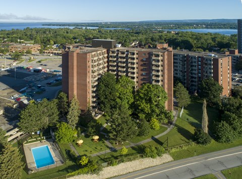 A large apartment complex with a pool and a parking lot.